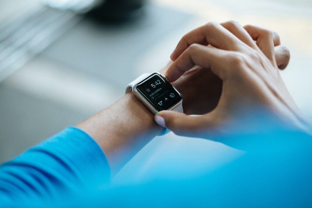 A close-up shot of a person's digital watch on their wrist, one hand is adjusting the settings.